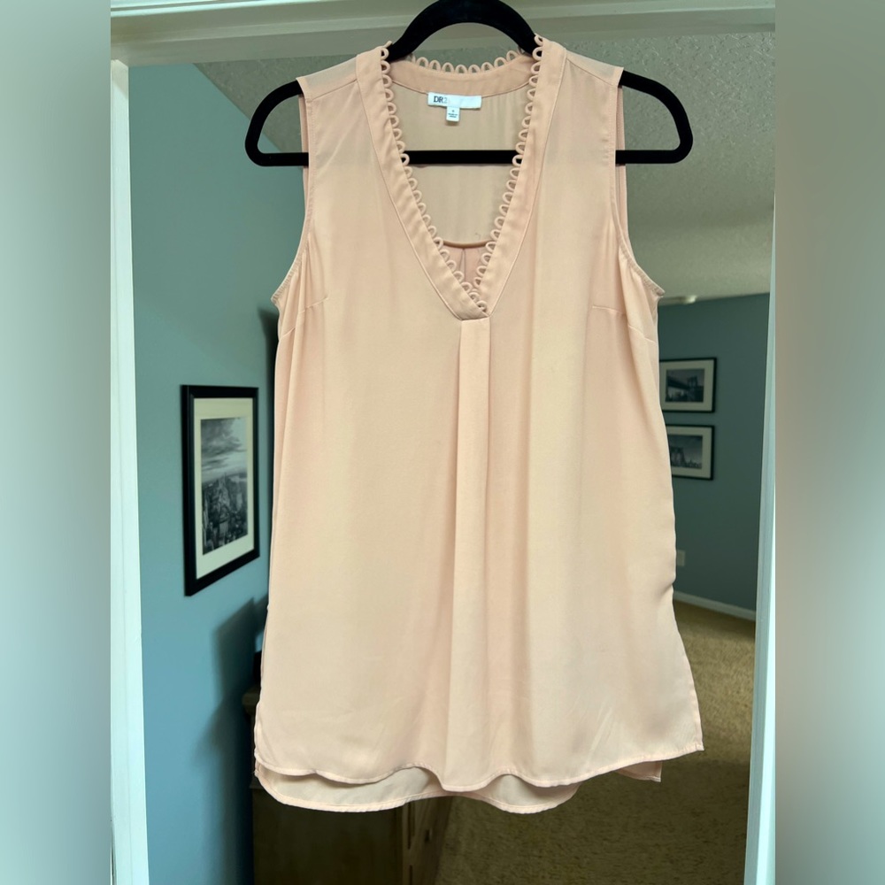 Soft pink sleeveless blouse.